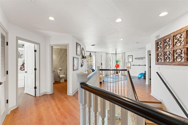 corridor featuring light hardwood / wood-style flooring and a textured ceiling