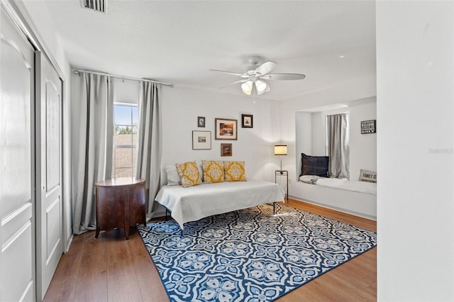 bedroom with hardwood / wood-style floors, ceiling fan, and a closet