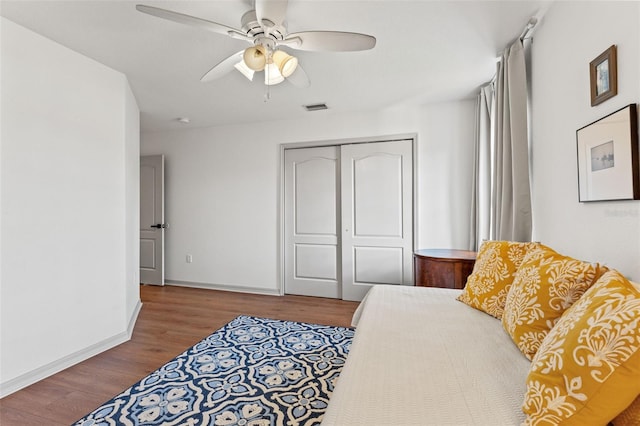 bedroom featuring ceiling fan, wood-type flooring, and a closet