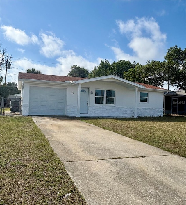 single story home with a garage and a front lawn