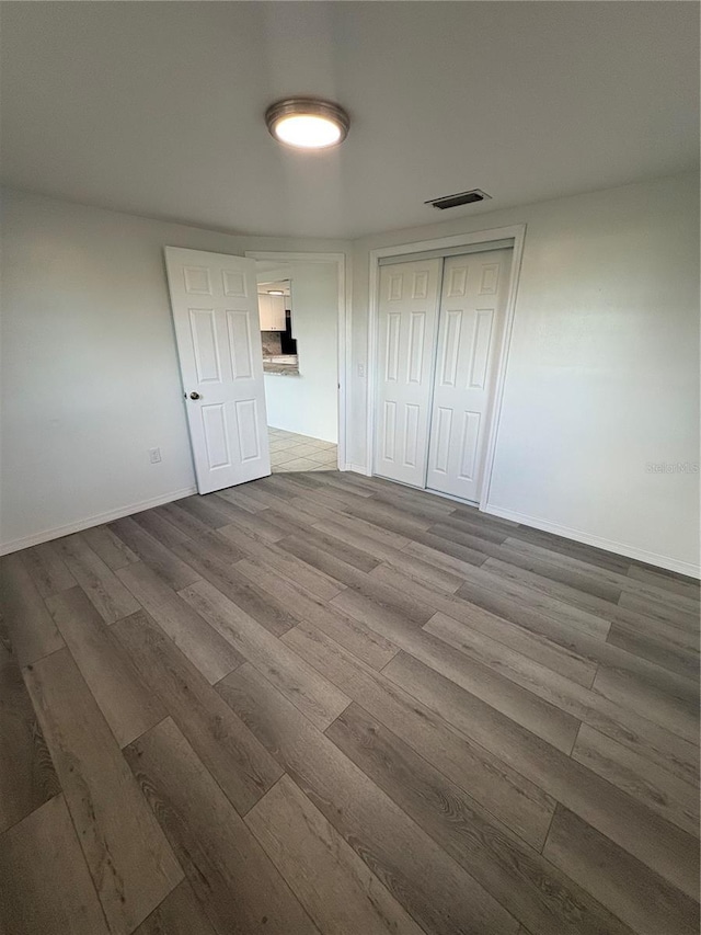 unfurnished bedroom with wood-type flooring and a closet