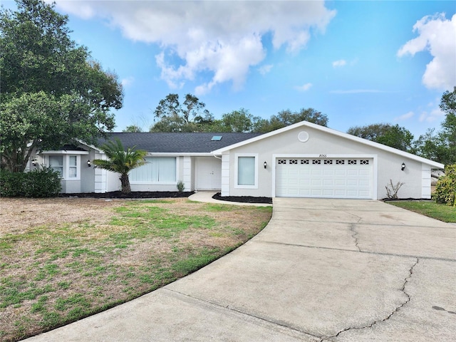 ranch-style house featuring a garage and a front yard