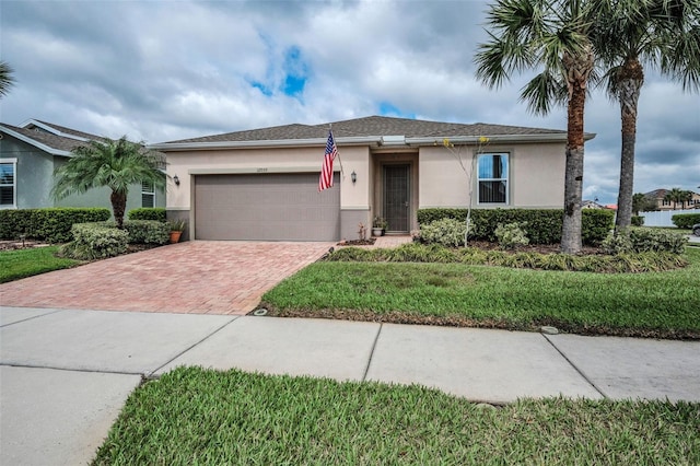 single story home featuring a garage, decorative driveway, and stucco siding