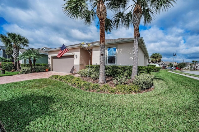 view of front of house with an attached garage, a front yard, and stucco siding