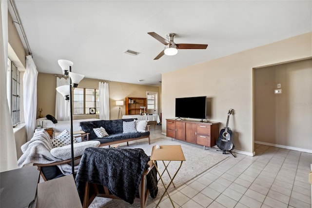 living area featuring visible vents, ceiling fan, baseboards, and light tile patterned floors