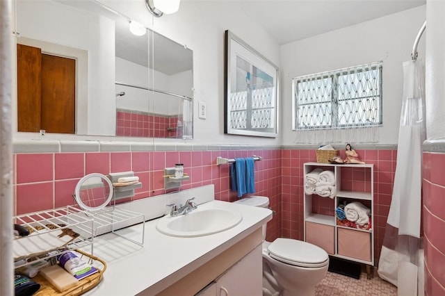 bathroom featuring toilet, a shower with curtain, a wainscoted wall, vanity, and tile walls