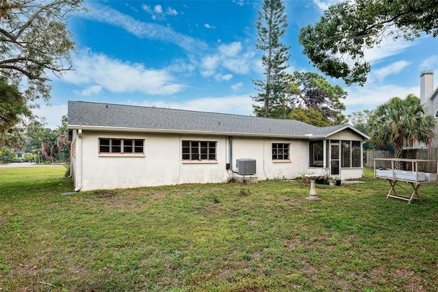 back of property with a sunroom, cooling unit, and a yard