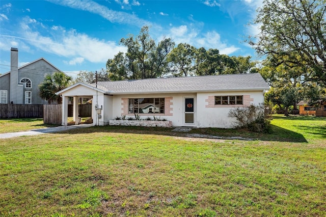 ranch-style home featuring an attached carport, fence, a front lawn, and stucco siding