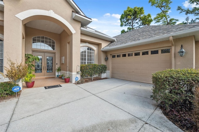 view of exterior entry featuring a garage and french doors