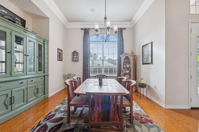 dining area featuring crown molding, an inviting chandelier, and hardwood / wood-style flooring