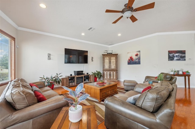 living room with crown molding, ceiling fan, and light wood-type flooring