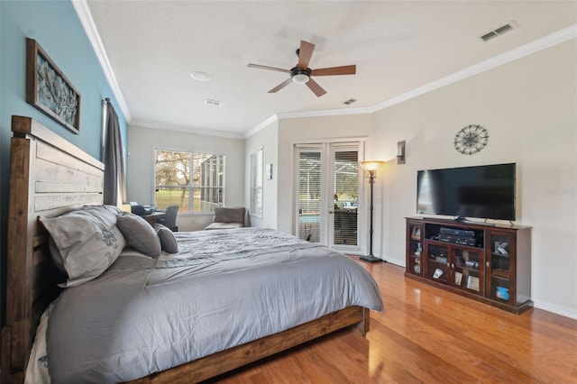 bedroom featuring hardwood / wood-style flooring, crown molding, multiple windows, and access to outside