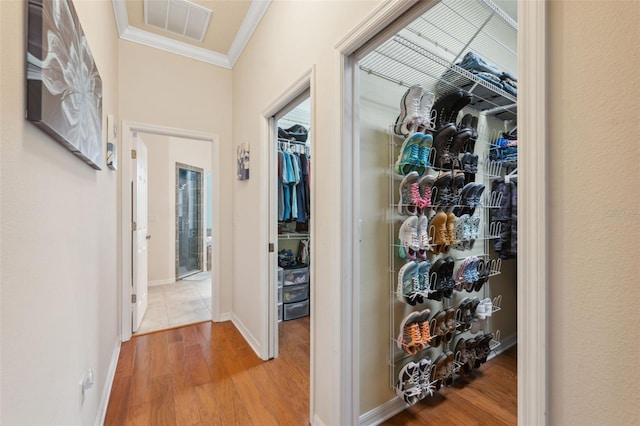 corridor with crown molding and light wood-type flooring