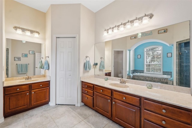 bathroom with tile patterned flooring, vanity, a tub, and toilet