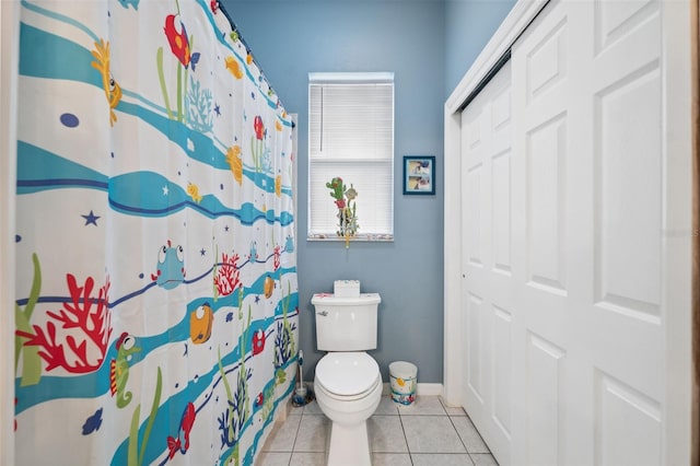 bathroom featuring tile patterned flooring, curtained shower, and toilet