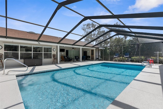 view of pool with ceiling fan, a patio, and glass enclosure