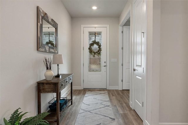 entryway with light wood-style flooring and baseboards