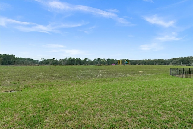 view of yard with fence and a rural view