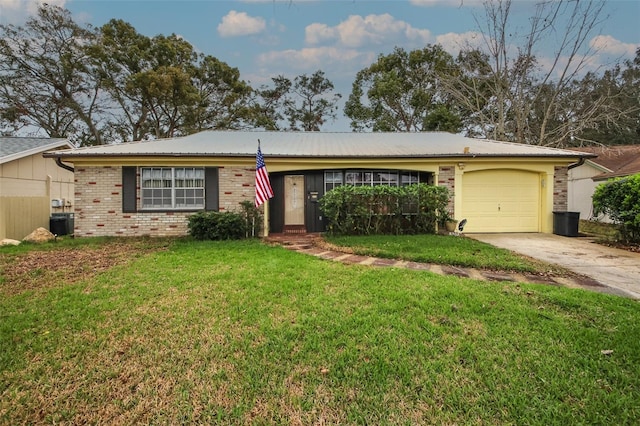 single story home with an attached garage, a front lawn, concrete driveway, and brick siding