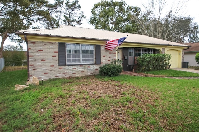 ranch-style house with metal roof, brick siding, an attached garage, and a front yard