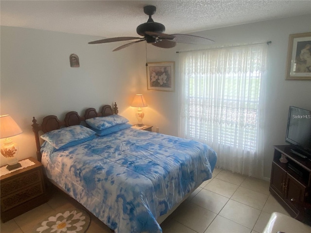 tiled bedroom featuring ceiling fan and a textured ceiling