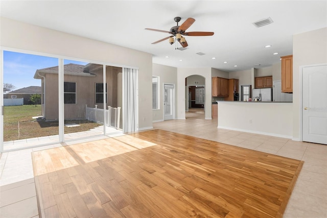 unfurnished living room with ceiling fan and light wood-type flooring