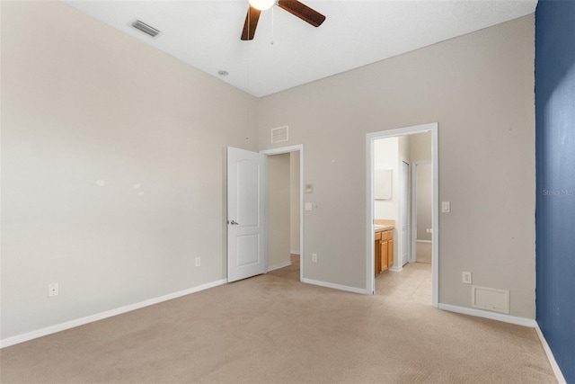 unfurnished bedroom with ceiling fan, ensuite bath, and light carpet