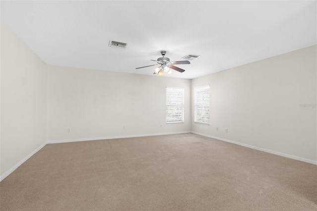 carpeted spare room with ceiling fan