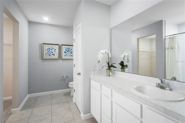 bathroom featuring toilet, vanity, and tile patterned flooring