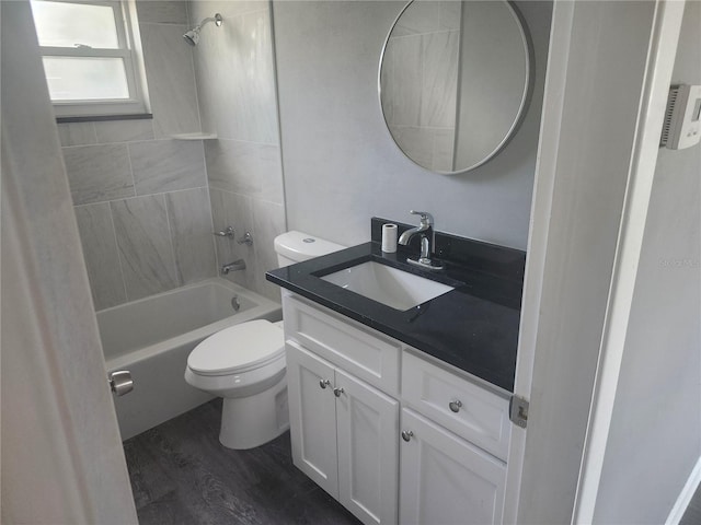 full bathroom with vanity, wood-type flooring, toilet, and tiled shower / bath