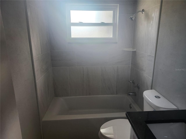 full bathroom featuring vanity, tiled shower / bath combo, and toilet