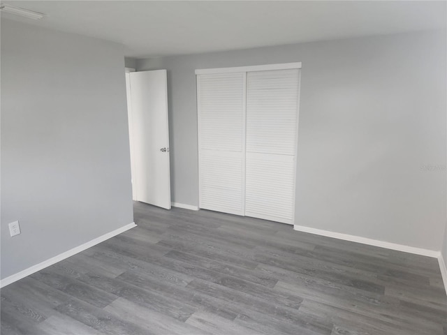 unfurnished bedroom featuring dark hardwood / wood-style flooring and a closet