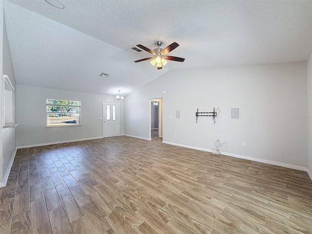 interior space featuring visible vents, a ceiling fan, wood finished floors, vaulted ceiling, and a textured ceiling