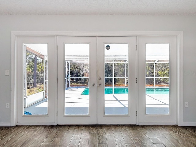 doorway to outside with french doors, a healthy amount of sunlight, baseboards, and wood finished floors