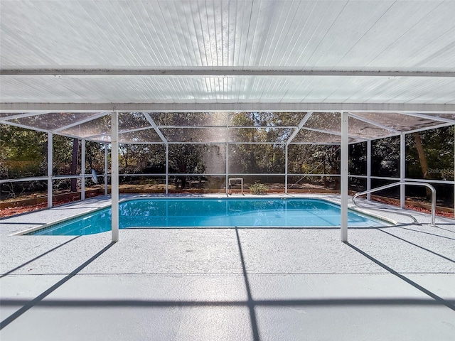 pool with glass enclosure and a patio