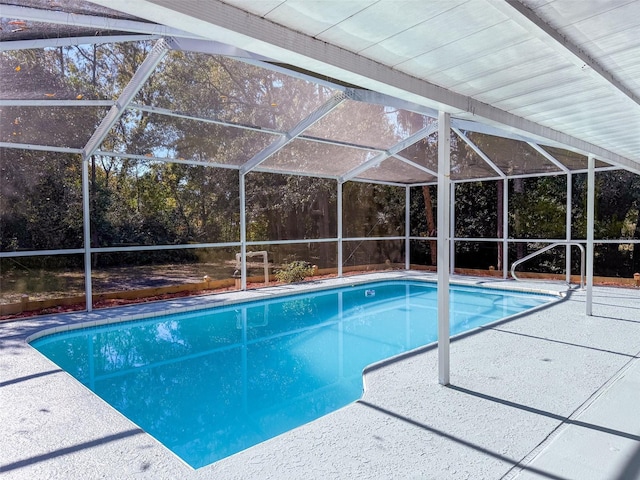 outdoor pool featuring glass enclosure and a patio