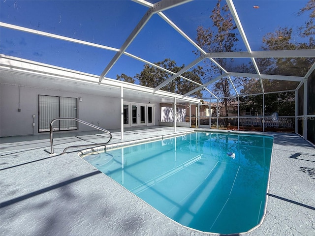 pool featuring glass enclosure, french doors, and a patio