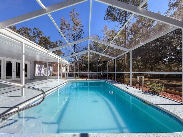 outdoor pool featuring french doors, glass enclosure, and a patio