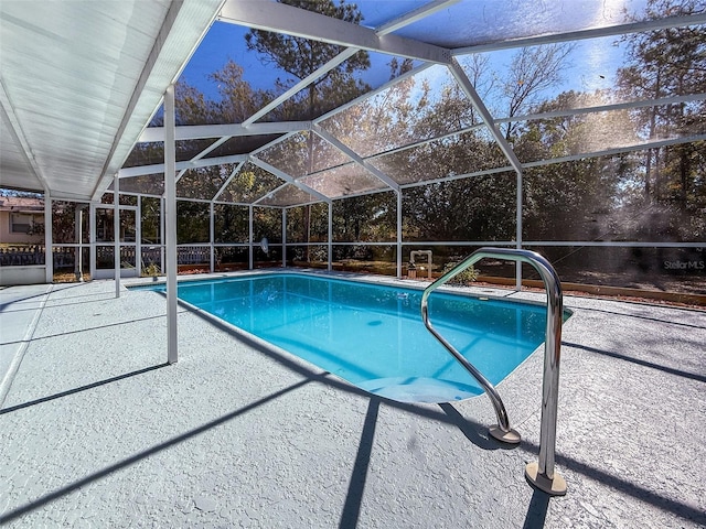 pool featuring glass enclosure and a patio area