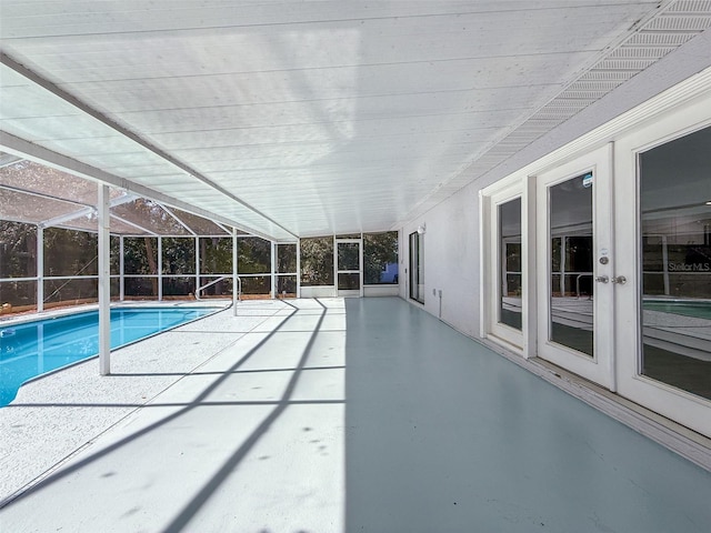 pool with a lanai, a patio area, fence, and french doors