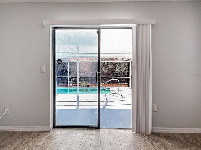 doorway featuring light wood-style floors and baseboards