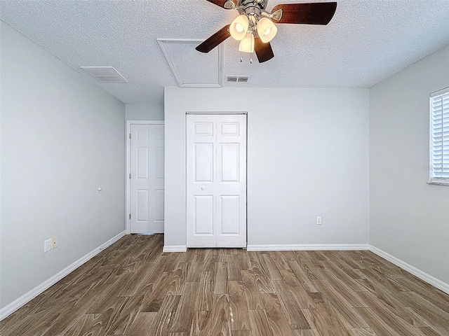 unfurnished bedroom with wood finished floors, visible vents, and baseboards