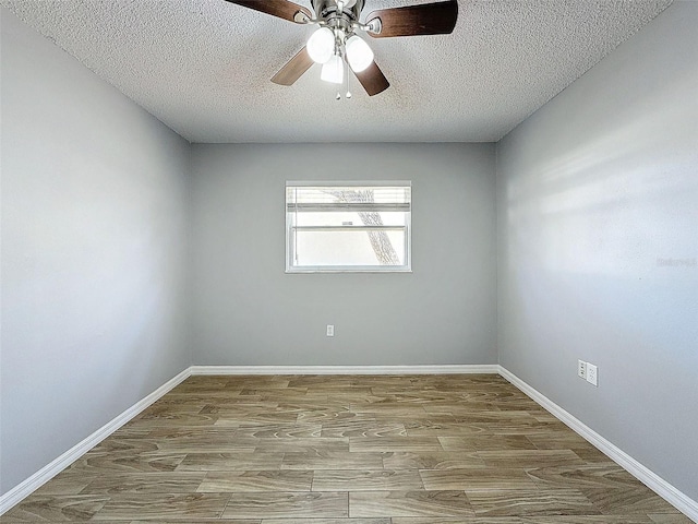 empty room featuring a ceiling fan, a textured ceiling, baseboards, and wood finished floors