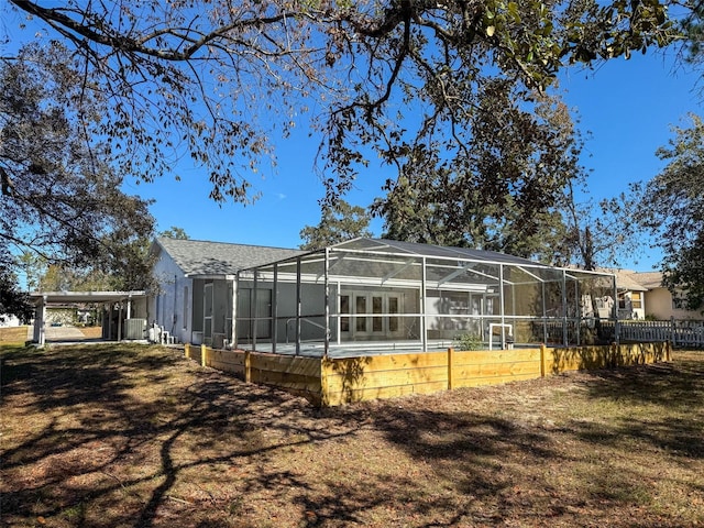 back of house with glass enclosure, a pool, and central AC