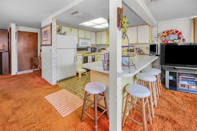 kitchen with visible vents, a peninsula, white appliances, light colored carpet, and light countertops