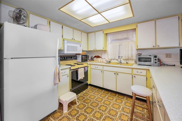 kitchen featuring a sink, white appliances, light countertops, tile patterned floors, and a toaster