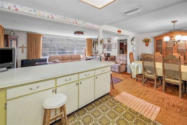 kitchen featuring light countertops, a notable chandelier, open floor plan, and visible vents