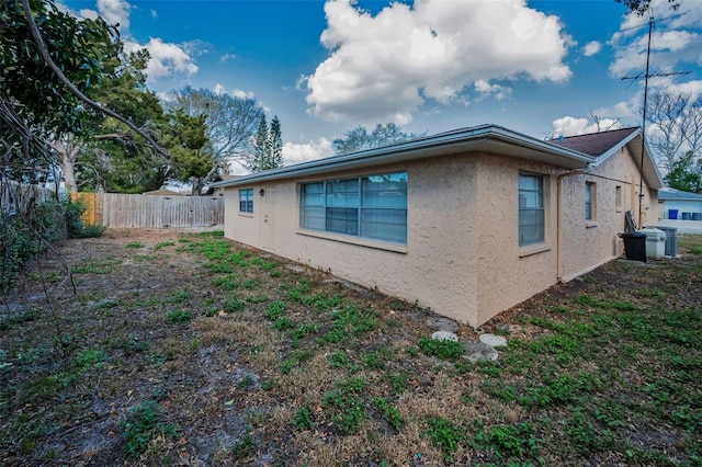 view of property exterior featuring fence and stucco siding