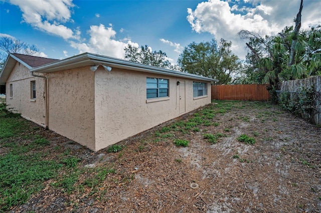 view of home's exterior with fence and stucco siding