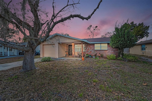 ranch-style house with a garage, driveway, and covered porch